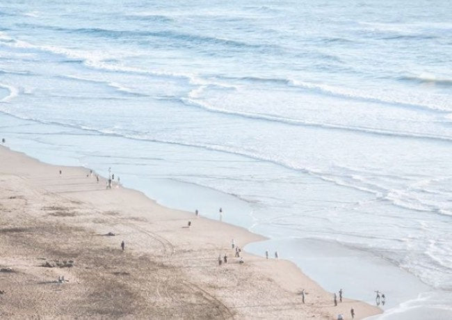 Beach with people walking on the sand