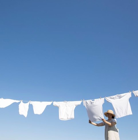 Woman hanging white tshirts on a clothes line